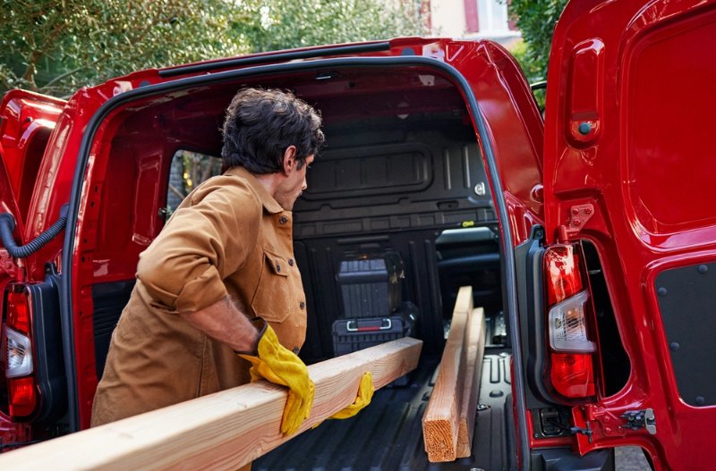 man loading up the van with wood