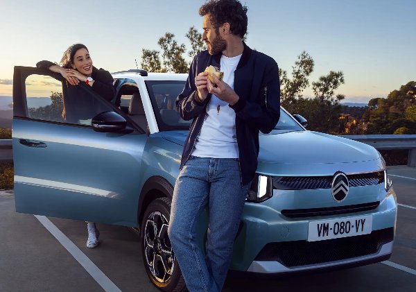 Two people are standing next to the car