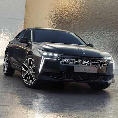 Sleek black car with distinctive grille and modern headlight design, viewed from the front side.