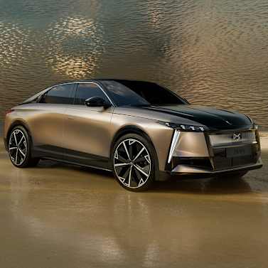 Sleek bronze-coloured car with black roof and modern headlights.