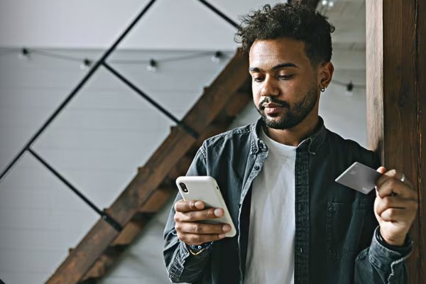 man standing with phone and car