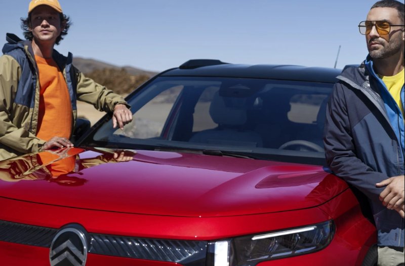 two people standing ewither side of a car