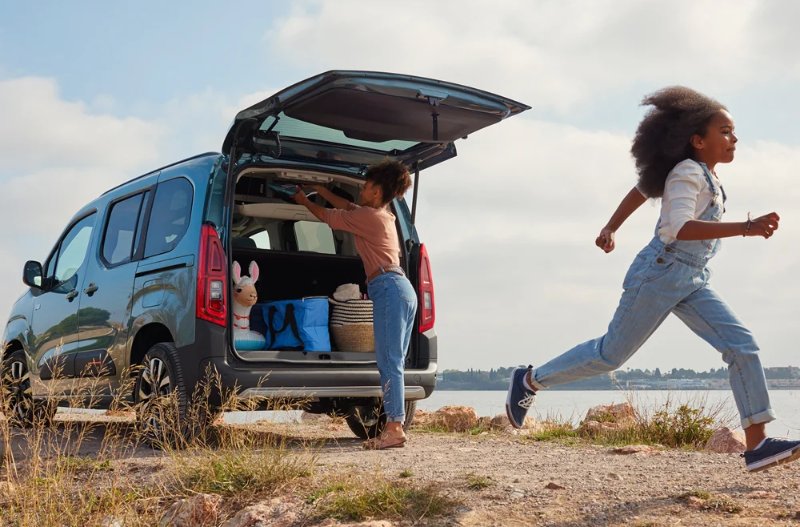 a kid running away from the car to go onto the beach