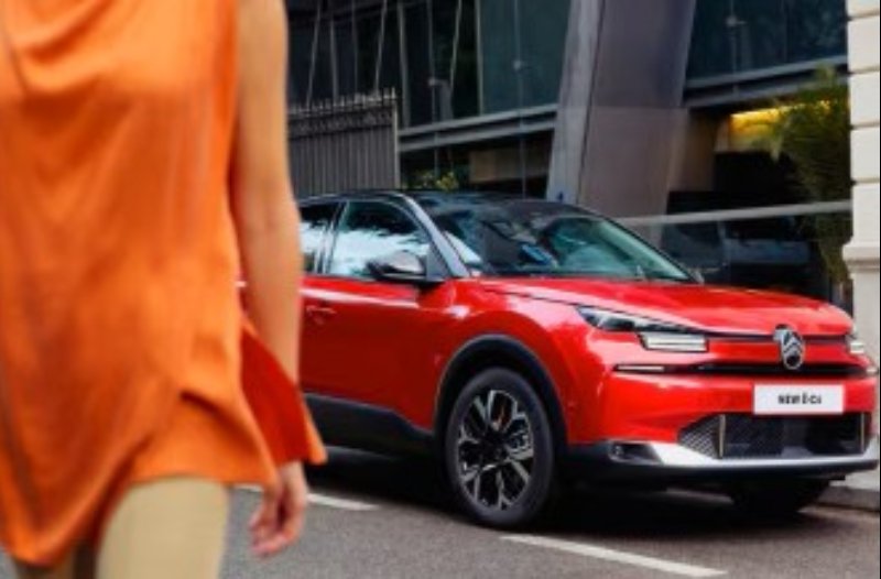 person in the foreground walking away from the car