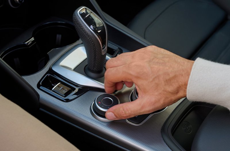 hand touching the gearstick of a car
