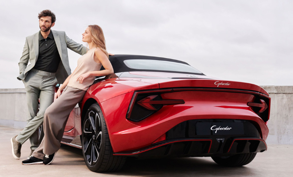 two people standing next to the car