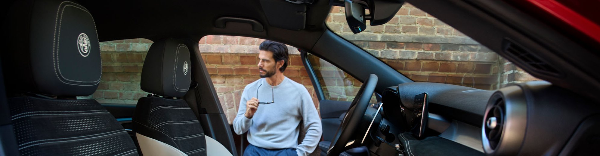 pan of the front of the car with man standing outside
